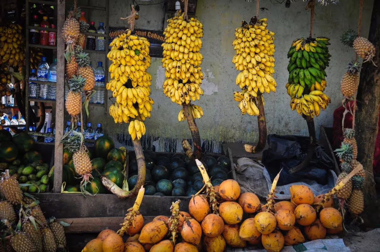 Vibrant fruit market in Kandy offering fresh bananas, pineapples, and coconuts, ideal for a culinary tour experience.
