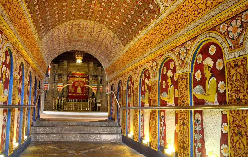 Vibrant mural-lined corridor inside the Temple of the Sacred Tooth Relic, capturing the essence of Kandy's cultural heritage.