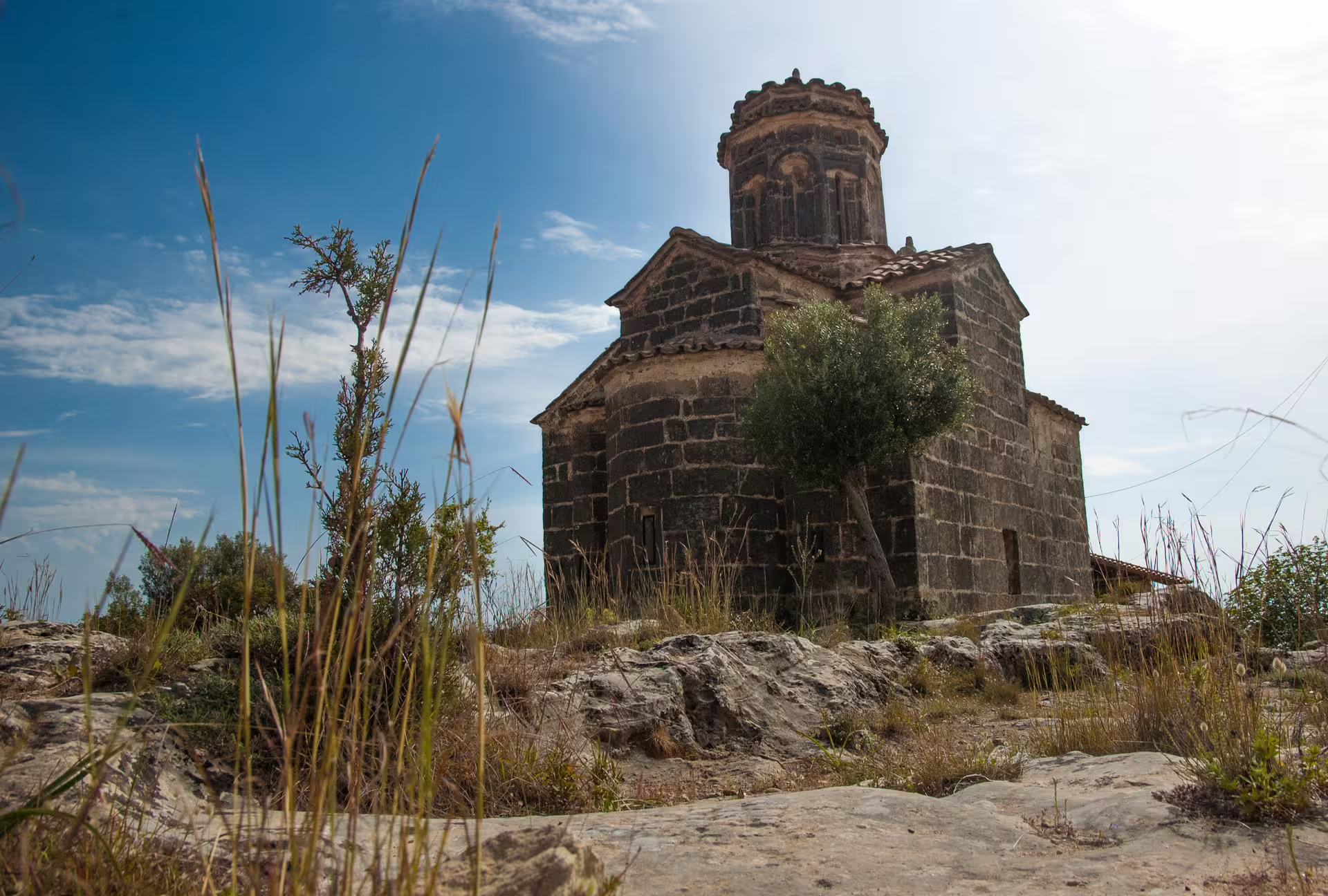 Byzantine stone church on the Kardamyli hiking route in Mani, Peloponnese, Greece under blue sky
