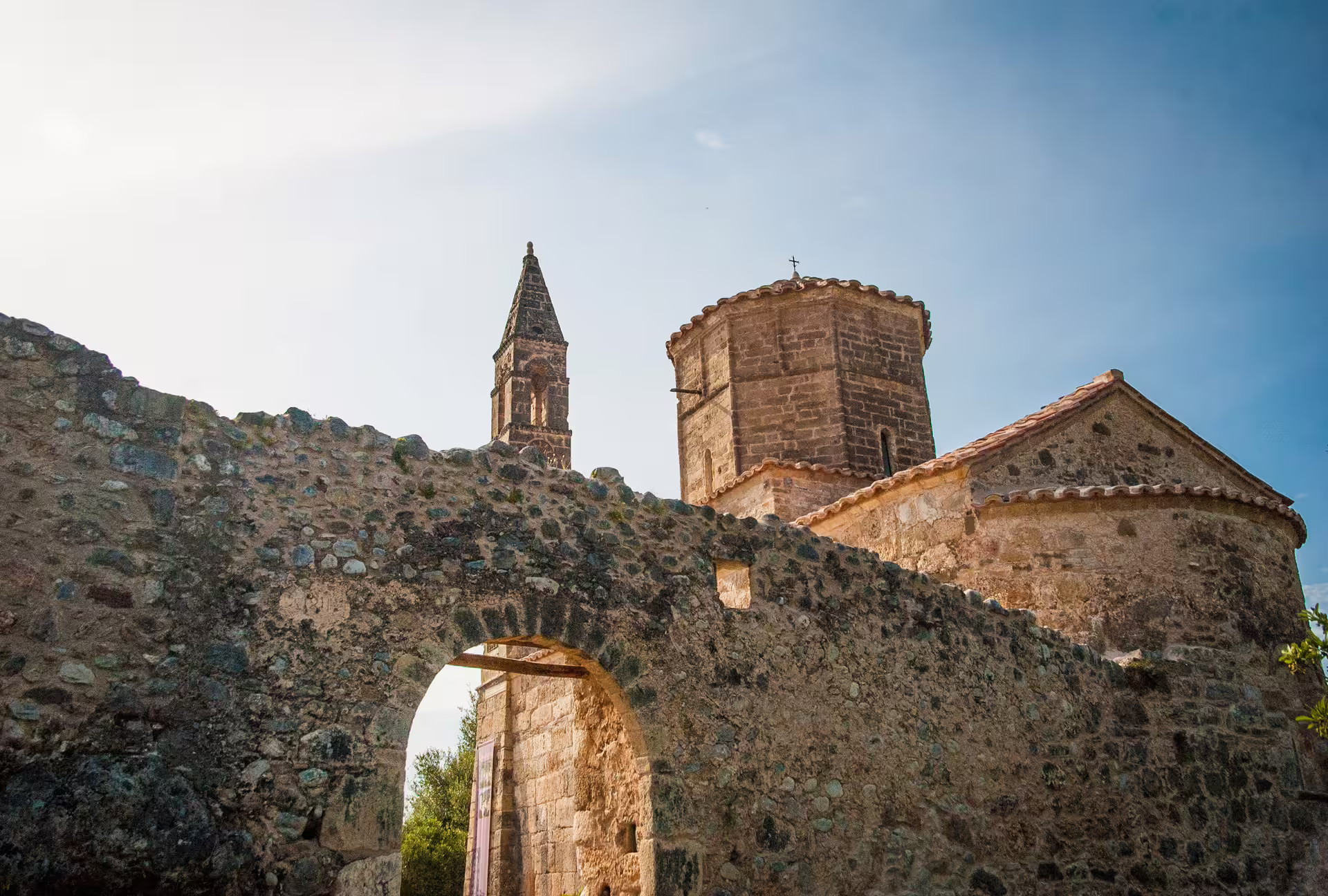 Stone arch and historic church towers on the Kardamyli hiking route in Mani, Peloponnese, Greece