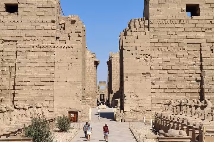 Stone corridor between massive Karnak Temple walls in Luxor, semi-private full-day tour from Hurghada with entry