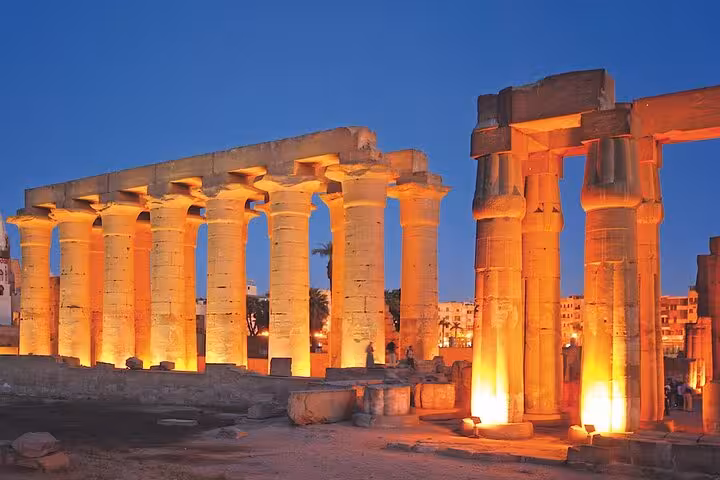 Illuminated columns at Karnak Temple during the Luxor Light & Sound Show with private transfer at dusk