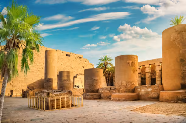 Karnak Temple courtyard in Luxor with towering columns and palm trees on a 5-day Cairo Luxor Abu Simbel tour