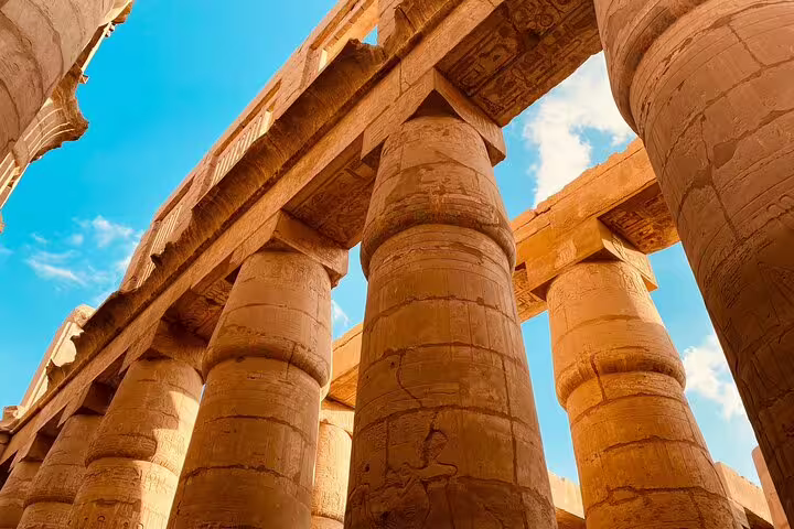 Towering columns of Karnak Temple in Luxor under blue sky, highlight of 5 days 4 nights Cairo to Luxor tour
