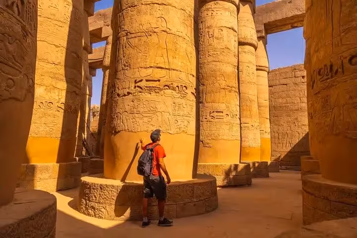 Traveler exploring Karnak Temple columns in Luxor on Sharm El Sheikh to Luxor day trip by plane