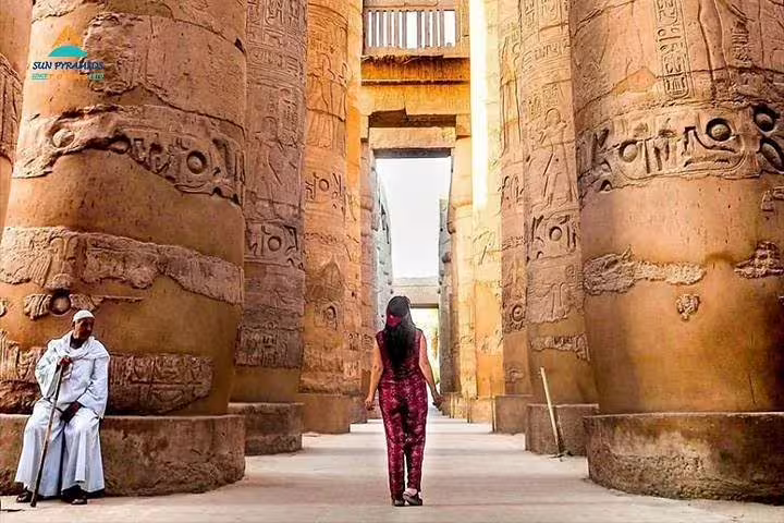 Walking between Karnak Temple columns in Luxor, highlight of the 2-day Cairo and Luxor tour from Hurghada
