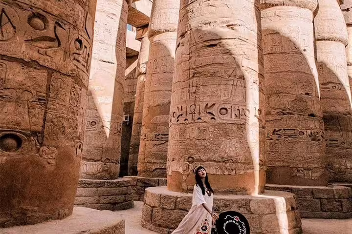 Tourist among giant Karnak Temple pillars in Luxor on private overnight tour from Cairo by flight, Egypt
