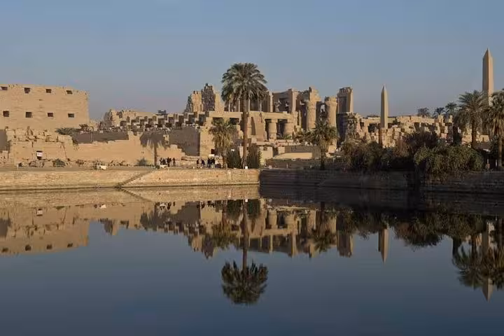Karnak Temple ruins reflected in the Nile at sunset, part of a private Luxor day trip from Hurghada