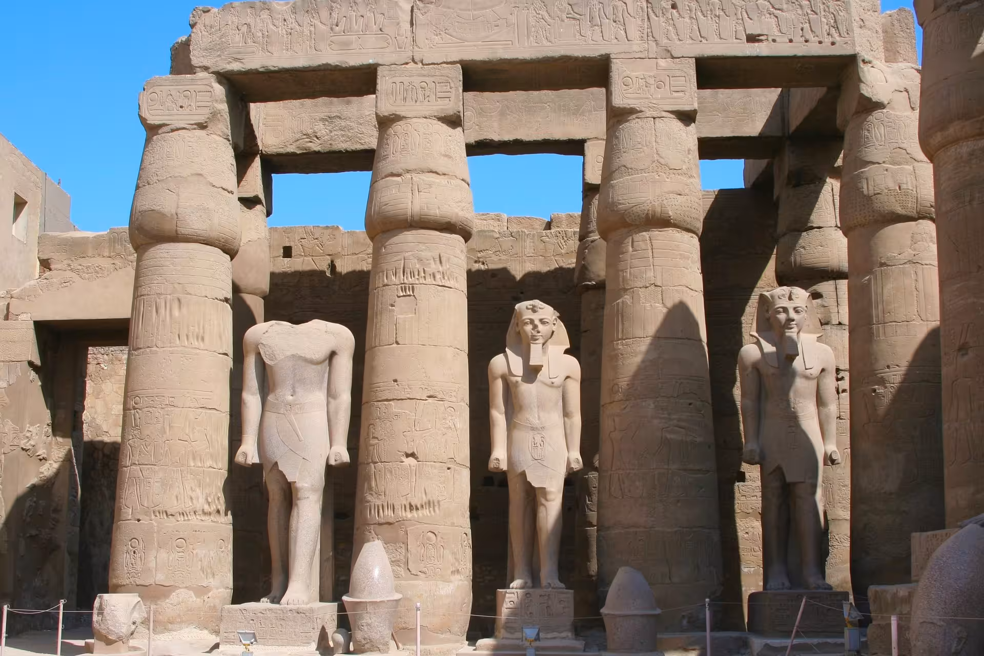 Colossal pharaoh statues and hieroglyphic columns at Karnak Temple, Luxor, Egypt