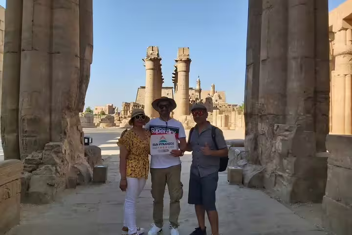 Travelers at Karnak Temple columns on private overnight Luxor tour from Cairo by flight with guide