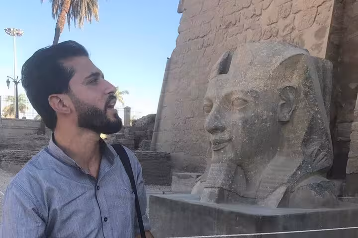 Guide beside a ram-headed sphinx at Karnak Temple, Luxor East Bank, private guided day tour experience