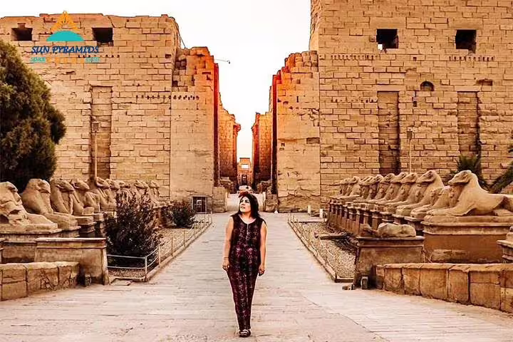 Visitor walking the sphinx-lined avenue at Karnak Temple, Luxor highlight on 15 days 14 nights Egypt package