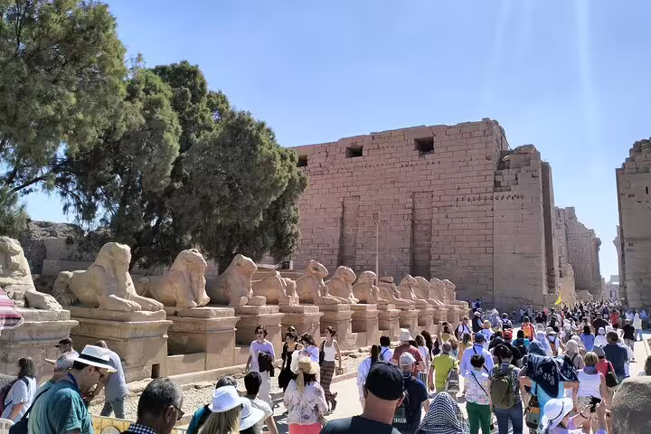 Crowds walking past sphinx statues at Karnak Temple, Luxor highlight on 14-day Egypt Nile Sahara desert bus tour