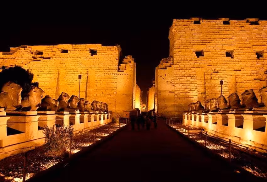 Karnak Temple avenue of ram-headed sphinxes lit at night, highlight of an evening Luxor tour in Egypt