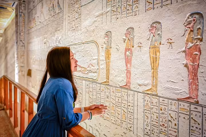 Visitor viewing ancient wall paintings at Karnak Temple, Luxor excursion from Marsa Alam with guide
