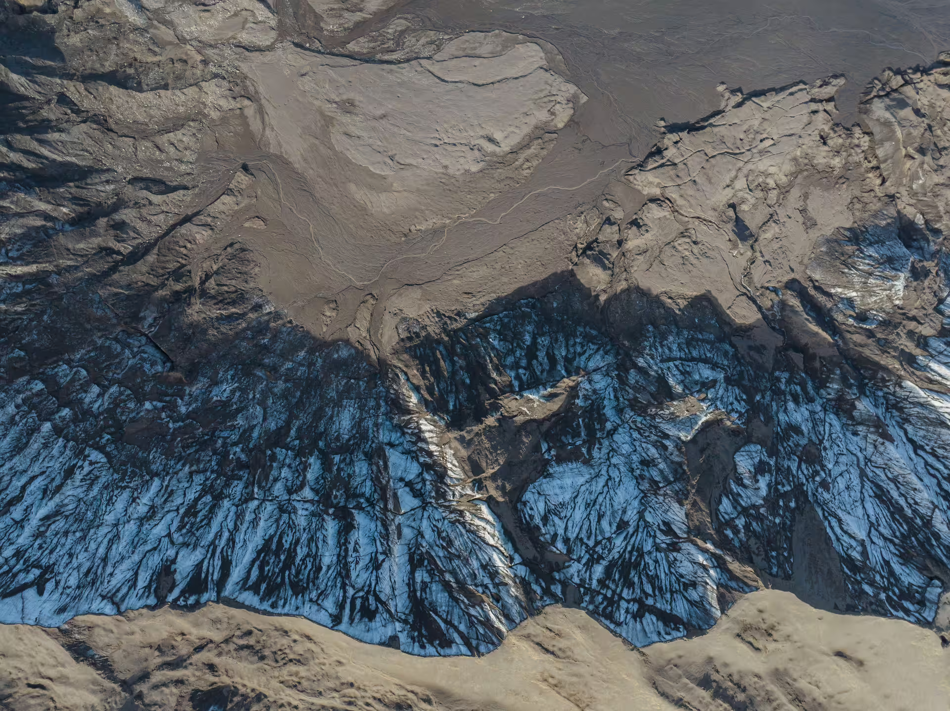 Aerial view of Katla glacier ice formations and volcanic ash layers on a guided research tour