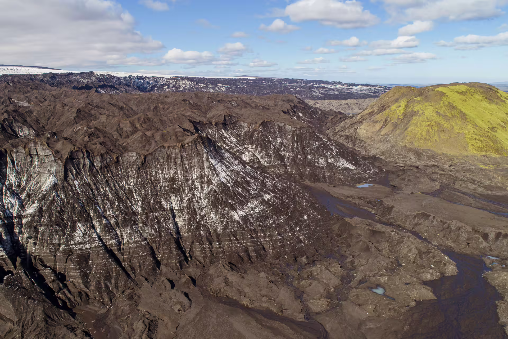 Dramatic Katla glacier landscape with black volcanic terrain and ice during a guided research tour