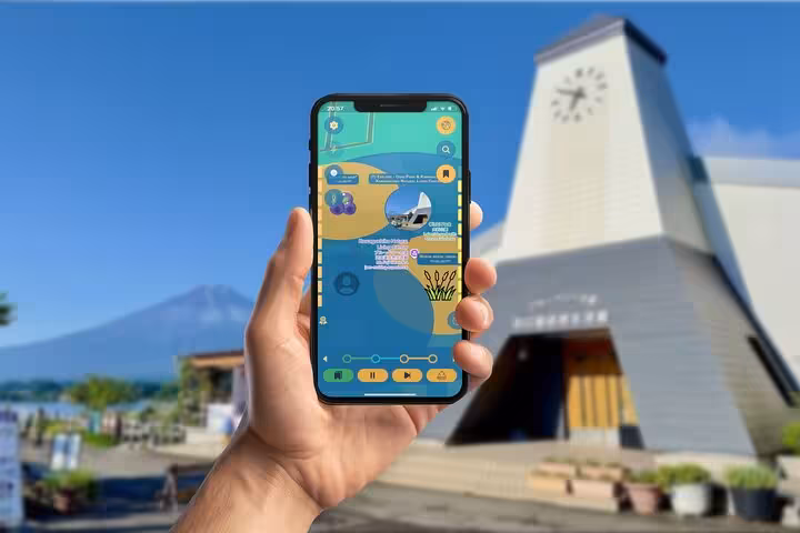 Hand holding smartphone with GPS city explorer app at Kawaguchiko with Mount Fuji in background