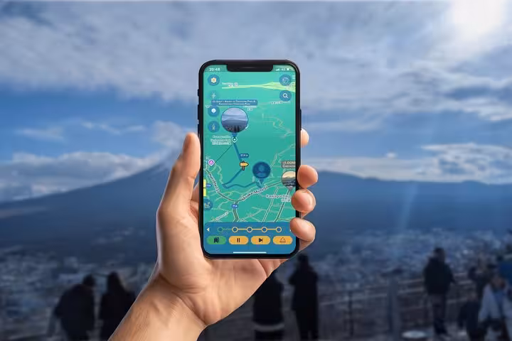 Hand holding smartphone with GPS navigation app near Mount Fuji at Kawaguchiko, Japan