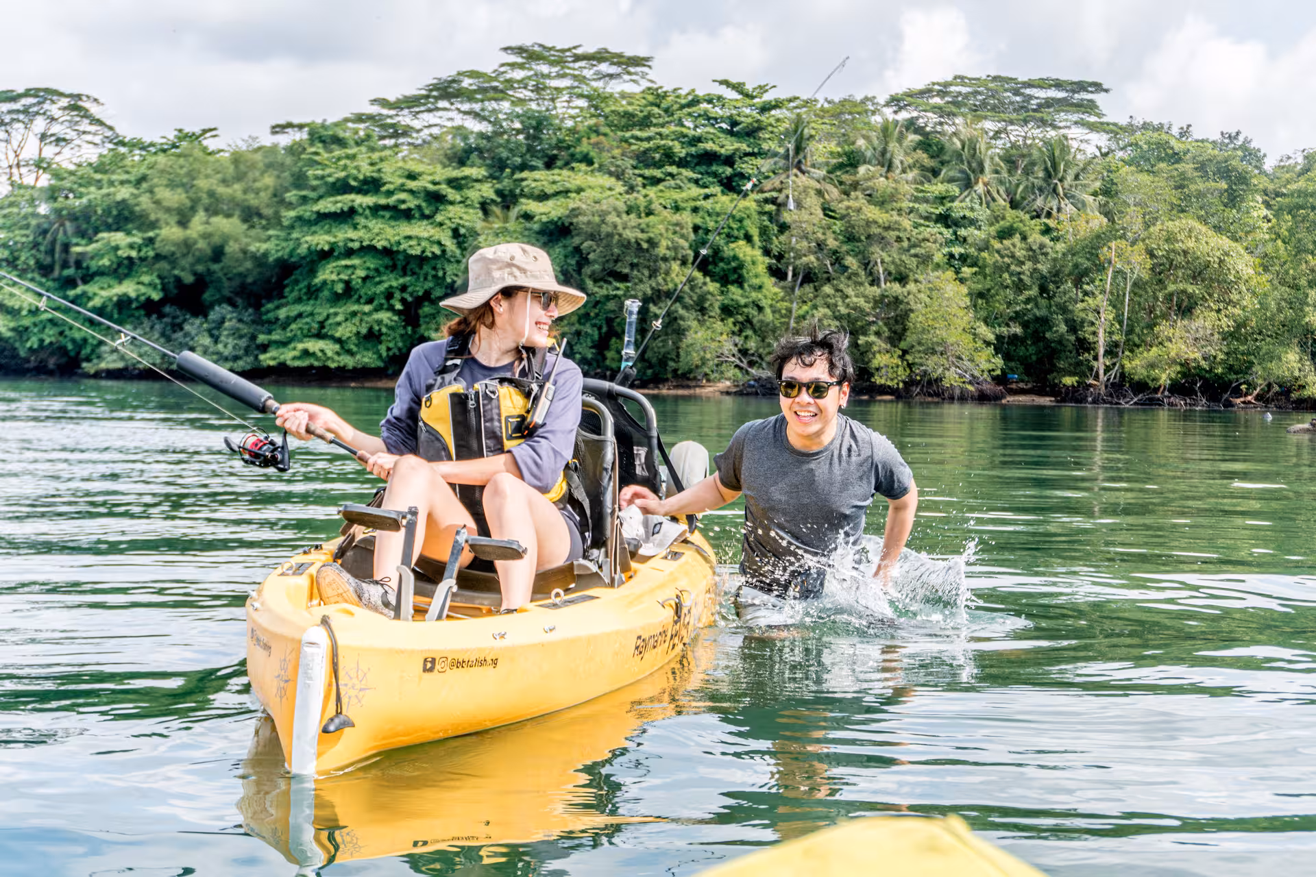 Adventurers enjoy kayak fishing in Pulau Ubin's mangroves, surrounded by lush greenery and serene waters.