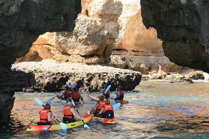 Guided kayak tour paddling into Ponta da Piedade sea caves in Lagos Algarve, exploring golden cliffs and coves