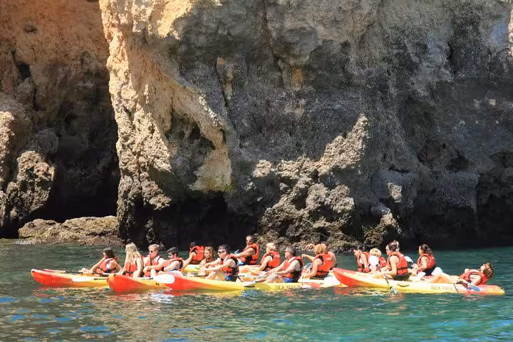 Group kayaking to Ponta da Piedade sea caves near Lagos, Algarve, guided tour beside dramatic cliffs
