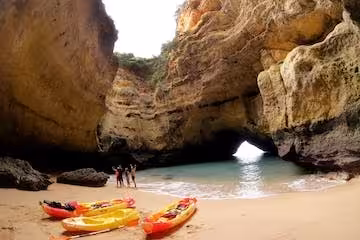 Kayaks on a sandy beach at the stunning Benagil Sea Cave, perfect for an adventurous Algarve kayak tour.