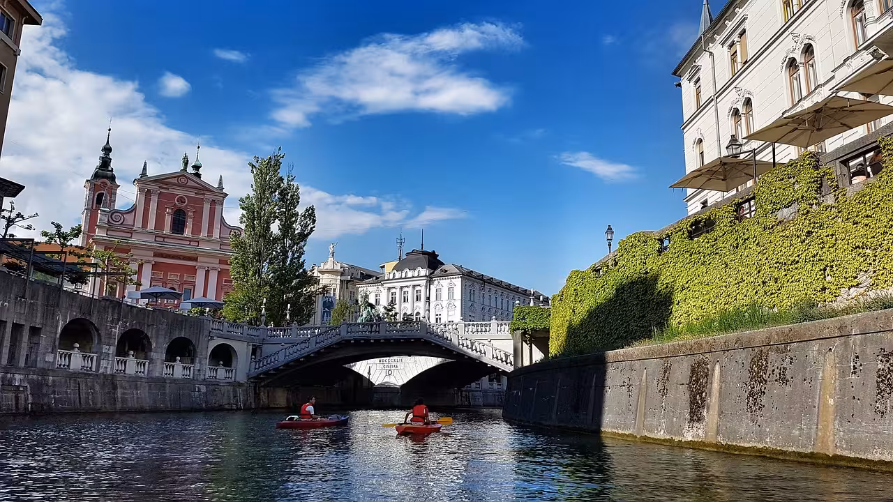 Kayakers on the Ljubljanica River by Triple Bridge and Franciscan Church, Ljubljana city tour highlight