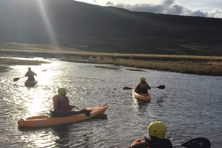 Kayakers paddle along the scenic Svartá River, surrounded by stunning Icelandic landscapes during an adventurous kayak trip.