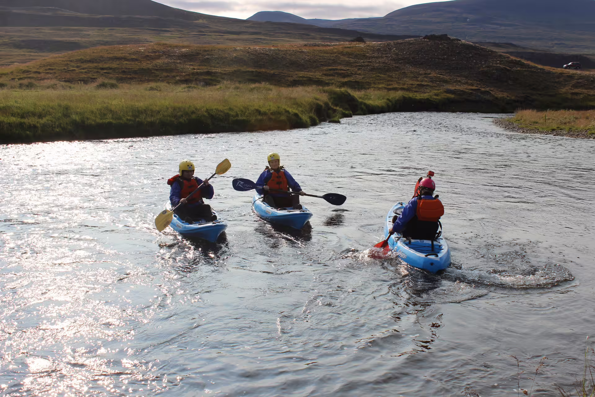 Kayakers paddle along the scenic Svartá River, surrounded by lush Icelandic landscapes, perfect for an adventurous outdoor excursion.
