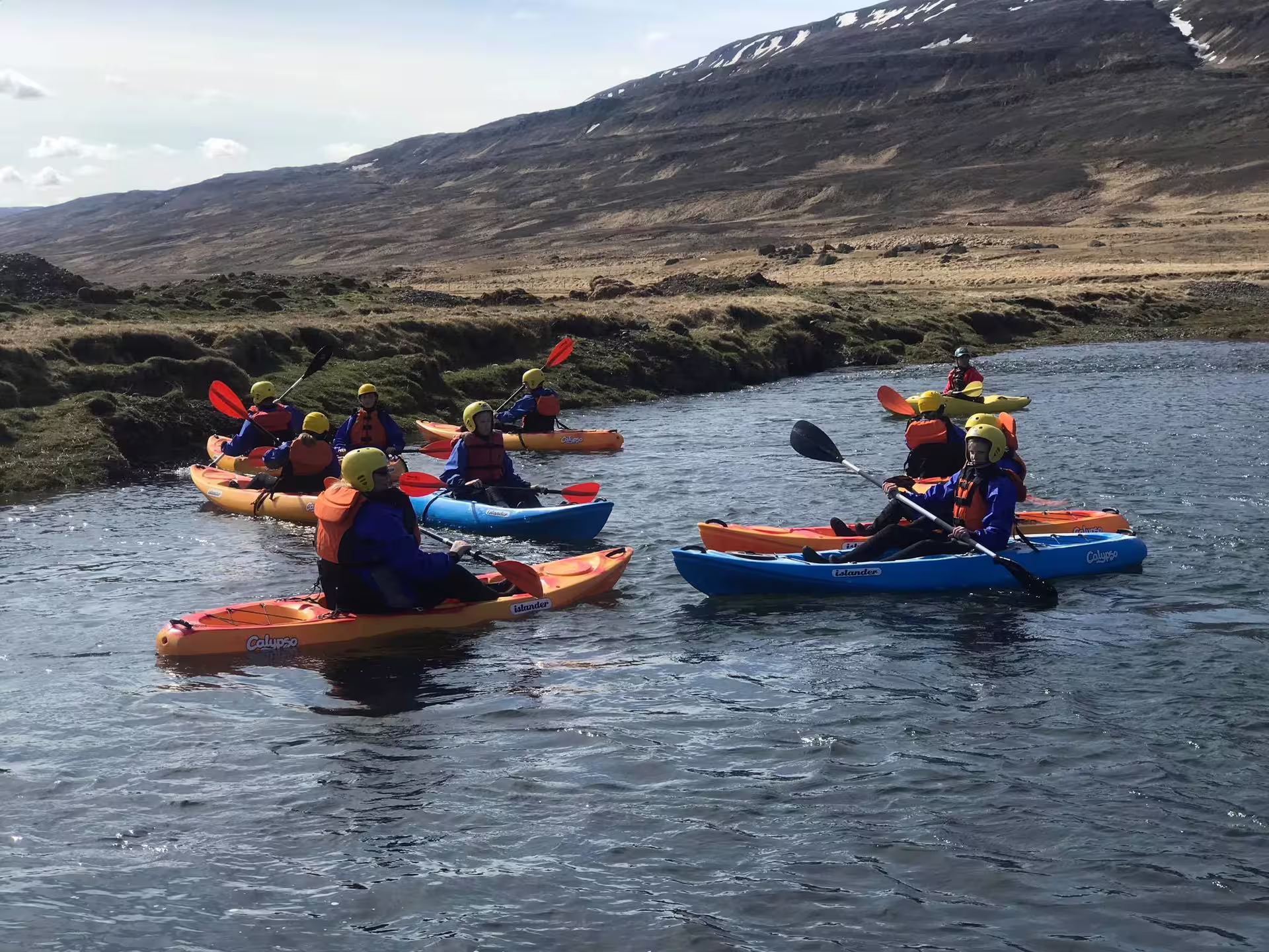 Kayakers navigate the scenic Svartá River surrounded by Iceland's rugged landscape on an adventurous kayak trip.