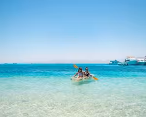 Two people kayaking in crystal clear turquoise waters near Giftun Island, Egypt