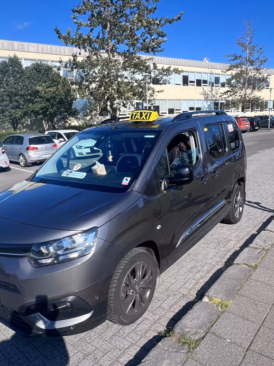 Black taxi minivan ready for private Keflavik Airport transfer to Reykjavik hotel, Iceland door-to-door ride