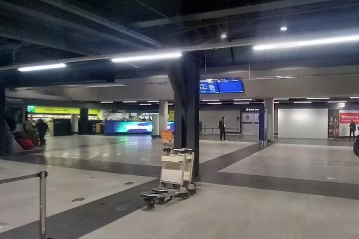 Keflavik Airport terminal interior with luggage cart and departure boards