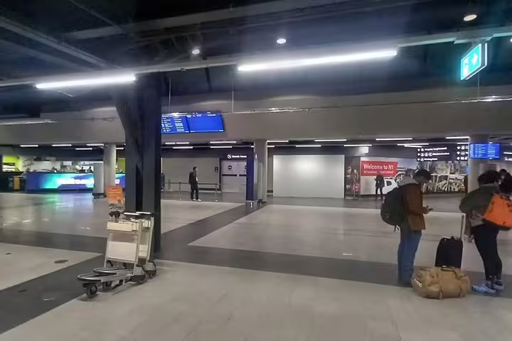 Keflavik Airport terminal interior with luggage carts and travelers near departure screens