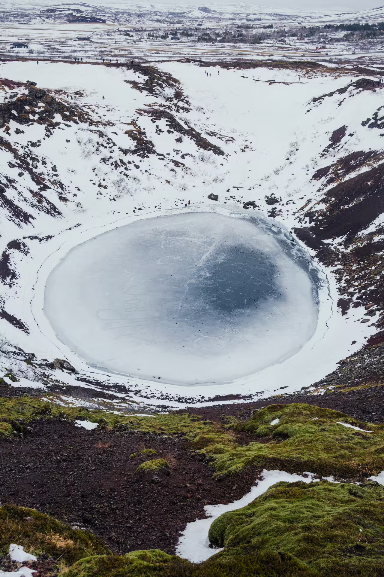 Frozen volcanic crater lake Kerid covered in snow during winter Golden Circle Iceland tour