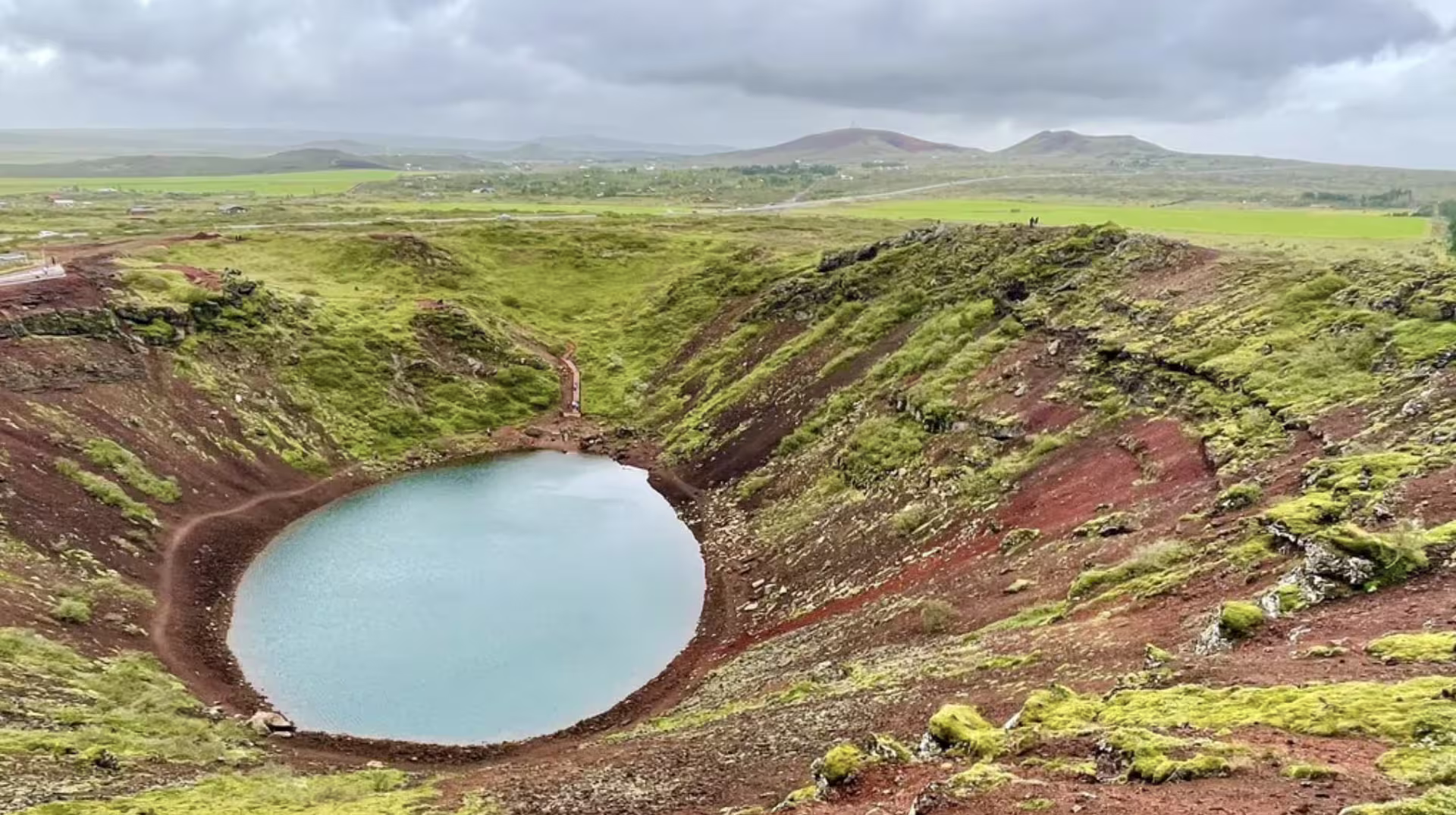 Kerid volcanic crater lake with turquoise water and red volcanic soil on Iceland's Golden Circle route