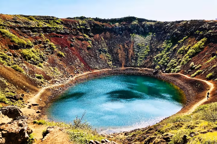 Kerid volcanic crater lake with vivid turquoise water surrounded by red and green slopes, Golden Circle Iceland