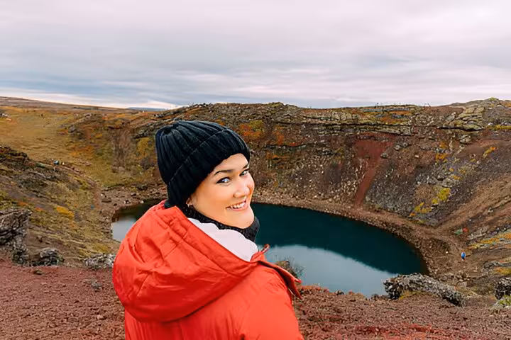 Smiling woman in red jacket at Kerid volcanic crater lake on Golden Circle tour from Reykjavik