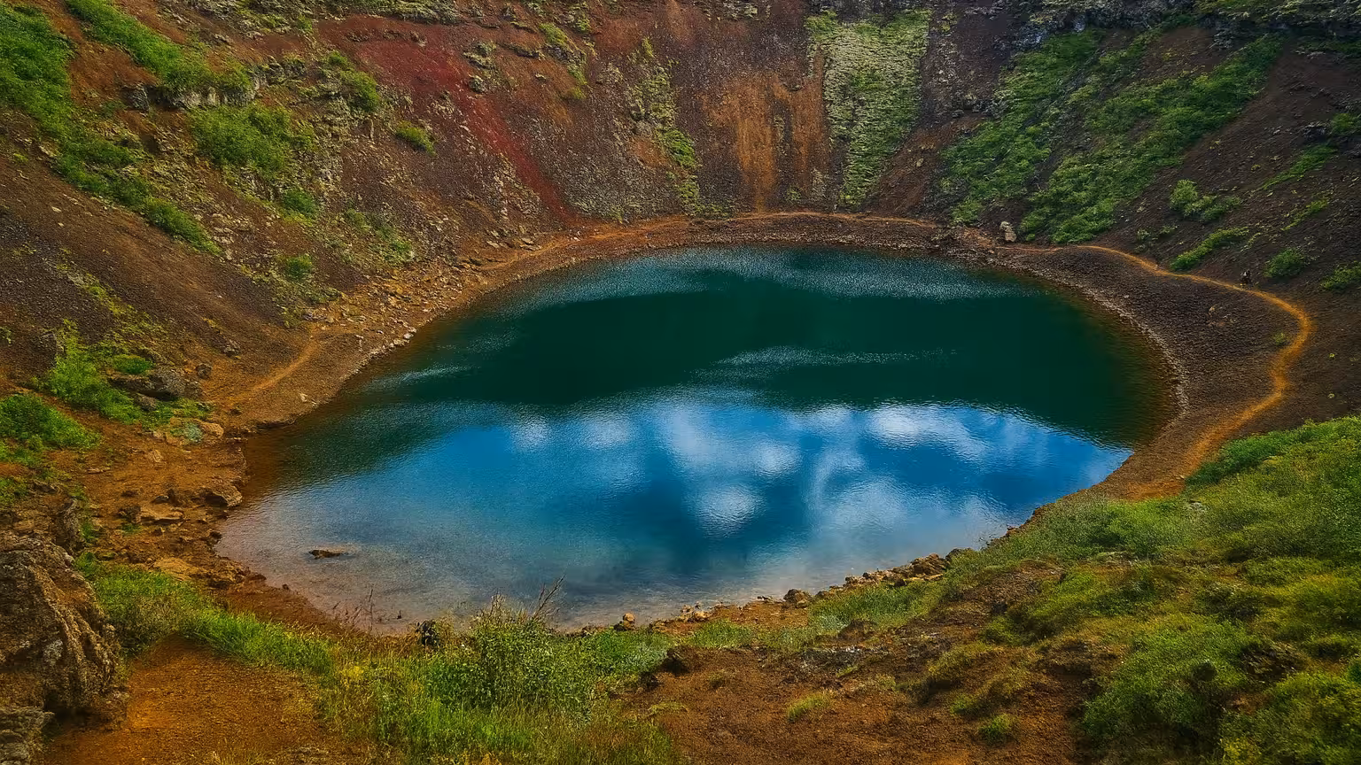 Scenic view of Kerid Crater Lake with vibrant red and green slopes, a highlight of the Golden Circle Private Tour.