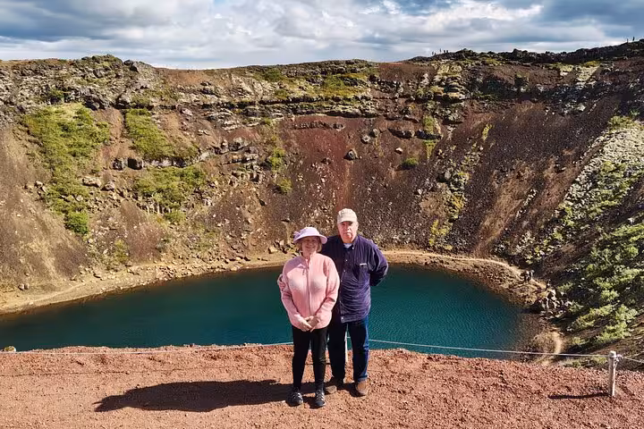 Couple posing in front of Kerid volcanic crater lake on a private Golden Circle Iceland sightseeing tour