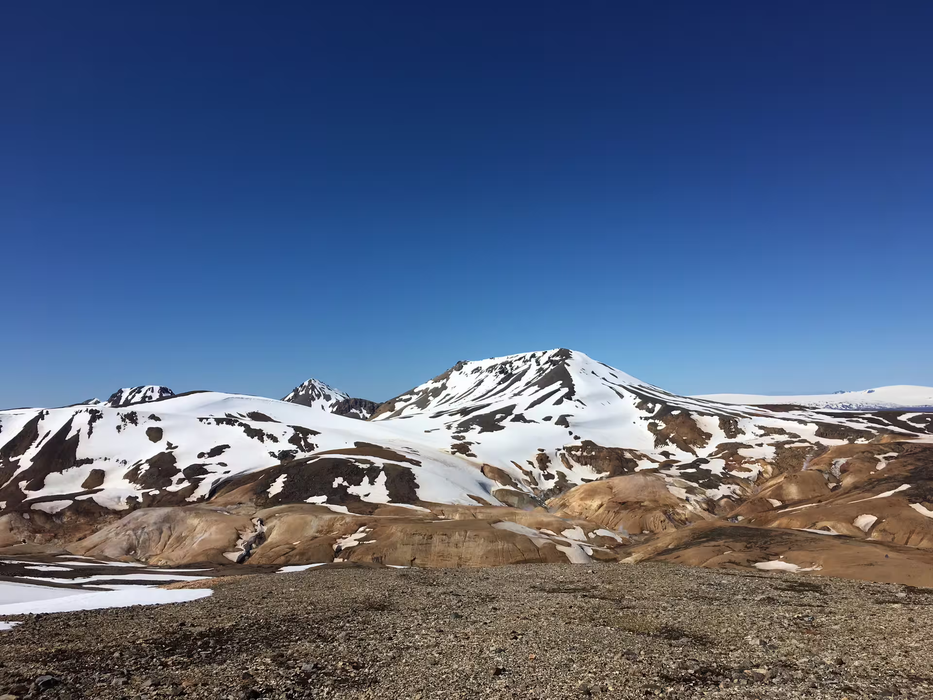 Snow-capped Kerlingarfjoll highlands mountains with volcanic rhyolite terrain under clear blue sky, Iceland