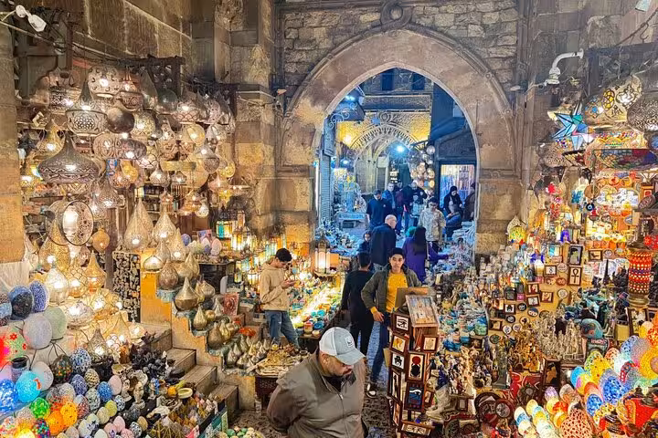 Khan El Khalili bazaar alley with glowing lanterns and souvenir stalls, Cairo shopping on guided tour