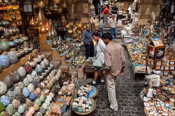 Shoppers explore lanterns and handmade souvenirs in Khan El Khalili bazaar during a Cairo day tour