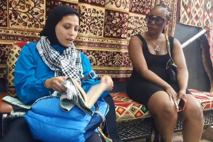 Traveler learning about Egyptian textiles while shopping at Khan el Khalili Market, Cairo, before koshary lunch
