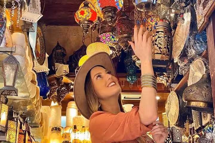 Visitor admiring colorful mosaic lanterns in Khan el-Khalili on a Historic Islamic Cairo walking tour