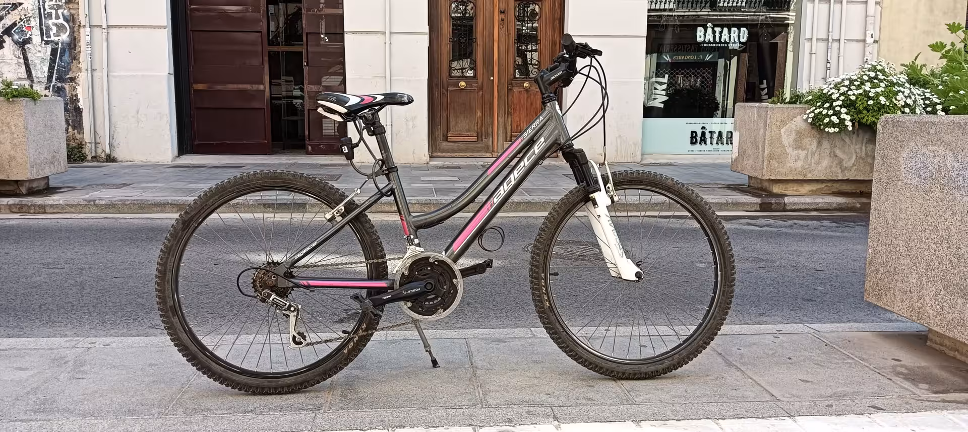 Single kids city bike rental parked curbside, lightweight frame and gears, perfect for safe city rides