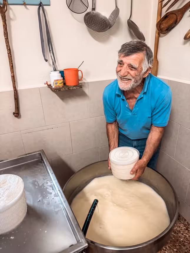 Local cheesemaker shaping fresh curds in a dairy kitchen, hands-on family farm experience for Kids First tour