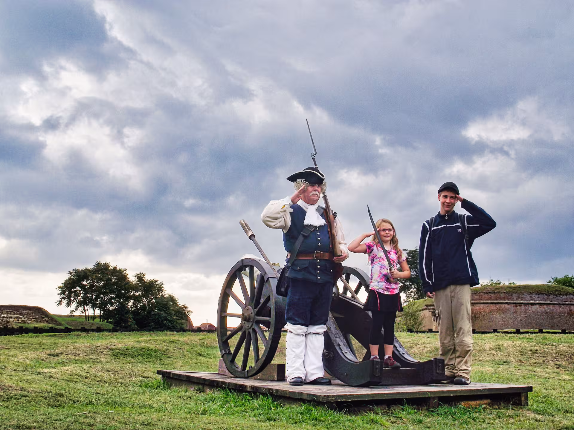 Kids posing with historical soldier reenactor and cannon at Corvin Castle guided tour from Cluj