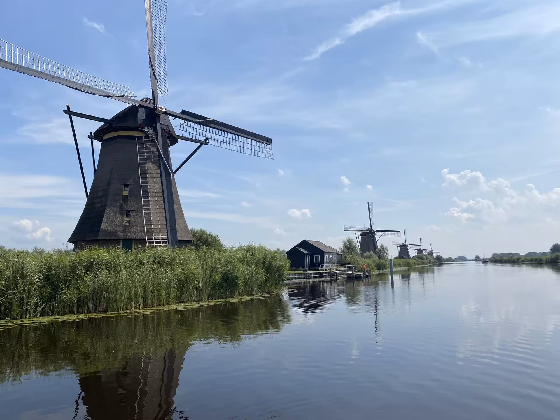 Kinderdijk windmill reflecting in canal on private tour from The Hague, Leiden or Noordwijk to Gouda and De Haar